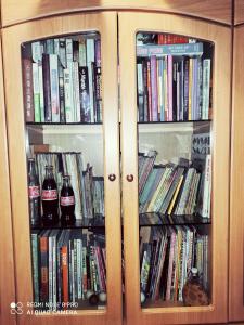 a cabinet with two glass doors full of books at New Garden View GF Double Room FREE parking in Batu Unjor
