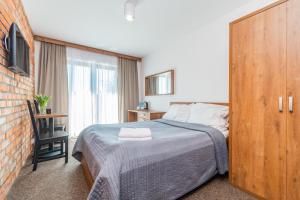 a bedroom with a bed and a large window at Baltik Park in Krynica Morska