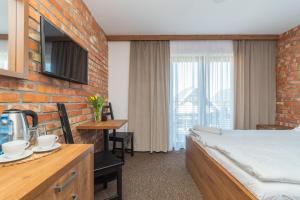 a hotel room with a bed and a table and chairs at Baltik Park in Krynica Morska