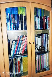 a wooden cabinet filled with lots of books at New Garden View GF Double Room FREE parking in Batu Unjor