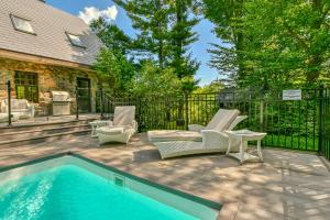 a patio with a pool and chairs next to a house at Panorama in Sainte Anne des Lacs