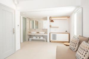 un bagno bianco con un lavandino e un divano di Manoula's Beach Mykonos Resort ad Agios Ioannis