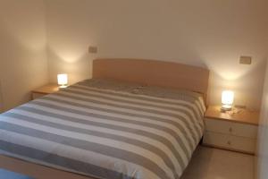 um quarto com uma cama e duas luzes em duas mesas em Confortevole Appartamento ad Aviano em Aviano