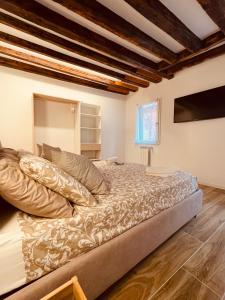 a large bed in a room with wooden floors at Suite Primo Piano in Venice