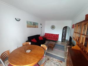 een woonkamer met een tafel en een rode bank bij Oura Li in Albufeira
