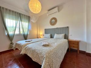 ein Schlafzimmer mit einem großen Bett mit einer weißen Tagesdecke in der Unterkunft Villa Liviana, Piscina Barbacoa y preciosas vistas Málaga by CostaDelSolEscapes in Cómpeta