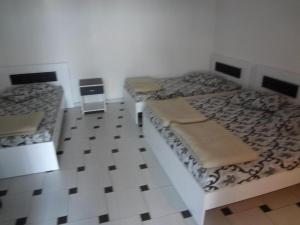 two beds in a room with a tiled floor at Apartments 64 in Star Dojran