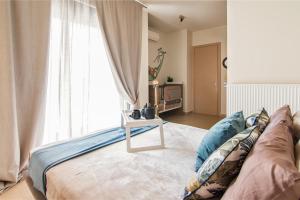 a living room with a couch and a window at Nefeli Residence in Alexandroupoli