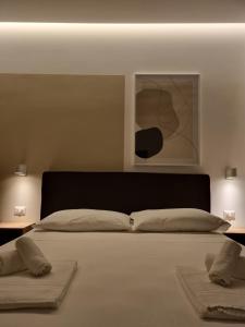 a bedroom with a large bed with two pillows at Marea Retreat Rooms in Marina di Camerota