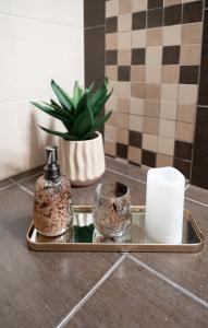 a tray with two bottles and cups on a bathroom counter at Nefeli Residence in Alexandroupoli