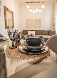 a table with a bowl and plates on a table at Nefeli Residence in Alexandroupoli