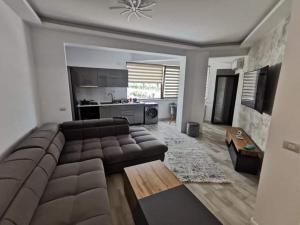 a living room with a brown couch and a kitchen at My home - Unique Luxury in Năvodari