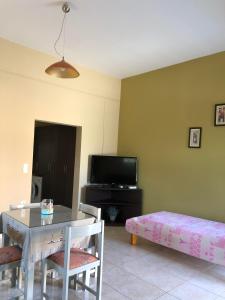 a living room with a table and a tv at THE CENTER in Xiropigado