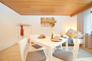 einen weißen Tisch und Stühle im Wohnzimmer in der Unterkunft GUN01-RI Apartment in Haundorf in Haundorf
