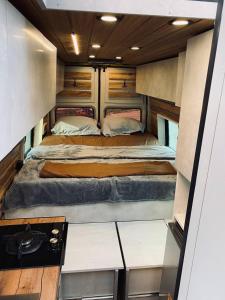 best camper van in tbilisi في تبليسي: سرير كبير وسط غرفة صغيرة