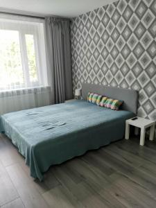 a bedroom with a large bed and a window at King Petera in Ventspils