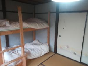 a room with two bunk beds and a door at ez guest house in Kyoto