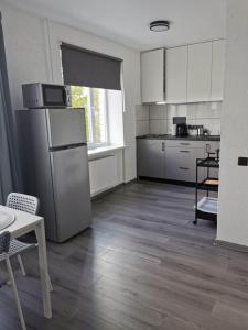 a kitchen with white appliances and a wooden floor at King Petera in Ventspils +6 photos