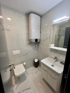La salle de bains blanche est pourvue d'un lavabo et de toilettes. dans l'établissement Sea & Sky Apartments, à Budva