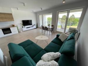 a living room with a green couch and a table at Apartament nad jeziorem Białym Augustów in Augustów +9 photos