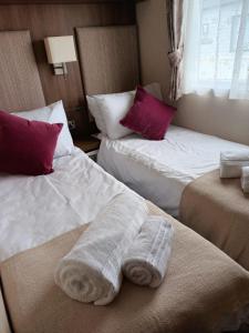 a hotel room with two beds with towels on them at Winchelsea Beach Holiday Home - Pool & Beach in Winchelsea