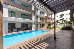 a swimming pool in front of a building at Modern 2 bedroom apartment - Soleia 2 Apartment A9 in Pereybere