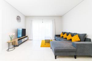 a living room with a blue couch and a tv at Modern 2 bedroom apartment - Soleia 2 Apartment A9 in Pereybere