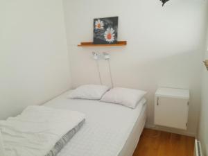 a small white room with a bed and a table at Lovely holiday apartment in Mellbystrand in Mellbystrand