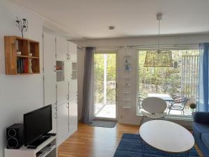 a living room with a couch and a table and a tv at Lovely holiday apartment in Mellbystrand in Mellbystrand