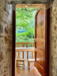 una puerta abierta a un porche con un banco en Kulla Hupi Agriturism, en Bulqizë