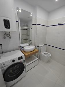 a bathroom with a washing machine and a toilet at Oxygen Neptun by BOUTIQUE 23 in Jupiter