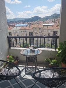 balkon z 2 krzesłami i stołem z widokiem w obiekcie 007 Apartments - TC Global, Strumica, Macedonia w mieście Strumica