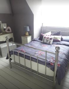 a bedroom with a bed with a blue comforter at Porthcawl cottage in Newton