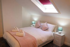 a bedroom with a bed with two teddy bears on it at Elegant Guest House FREE WiFi & Parking in Killingbeck