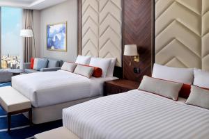 ジッダにあるJeddah Marriott Hotel Madinah Roadのベッド2台とソファが備わるホテルルームです。