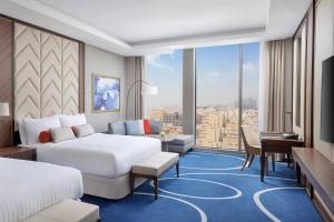 een hotelkamer met 2 bedden en een groot raam bij Jeddah Marriott Hotel Madinah Road in Jeddah