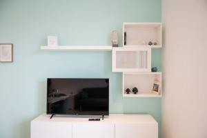 a living room with a tv and white shelves at San Pietro Panoramic House in Galatina