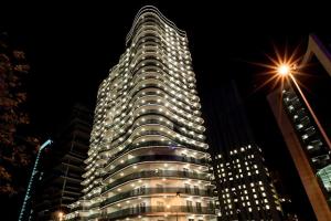 un edificio alto con luces encendidas por la noche en Versace Tower Luxury Suites - Downtown en Beirut