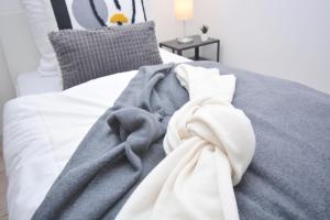 ein Bett mit einer grauen Decke und Kissen in der Unterkunft GUN03-RI Apartment in Haundorf in Haundorf