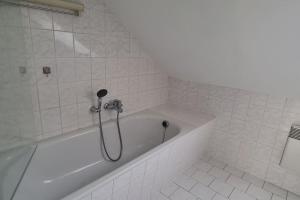 a white bath tub with a shower in a bathroom at Ganze 2-Raum Ferienwohnung Links in Baderitz
