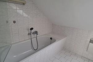 a white bath tub with a shower in a bathroom at Ganze 2-Raum Ferienwohnung Links in Jahnatal