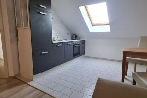 a kitchen with black cabinets and a window at Ganze 2-Raum Ferienwohnung Links in Jahnatal