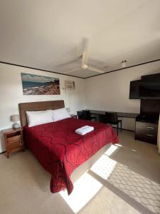 ein Schlafzimmer mit einem Bett mit einer roten Decke in der Unterkunft Wongai Beach Hotel in Horn