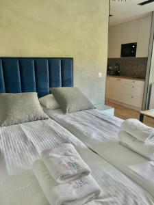 two beds in a room with towels on them at Carbon by OneApartments in Sopot