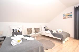 ein weißes Schlafzimmer mit 2 Betten und einem Sofa in der Unterkunft GUN03-RI Apartment in Haundorf in Haundorf