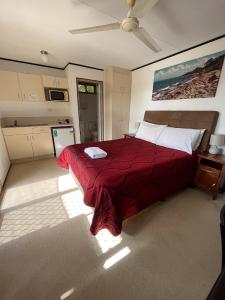 Wongai Beach Hotel في هورن: غرفة نوم بسرير كبير مع بطانية حمراء