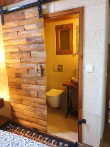 a bathroom with a toilet and a wooden wall at Avangart Hotel in Avanos