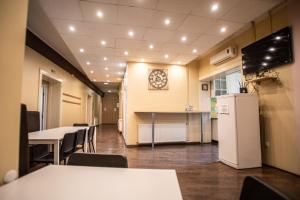 uma sala de conferências com mesas e cadeiras e uma geladeira em All in Hostel em Belgrado