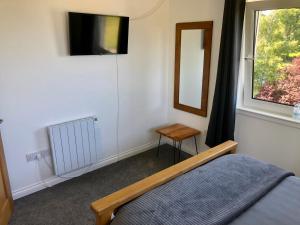 a bedroom with a bed and a mirror and a window at Brecbennoch in Oban