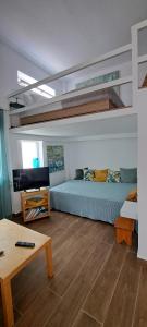 ein Wohnzimmer mit 2 Betten und einem Tisch in der Unterkunft Cosy loft in Platamonas